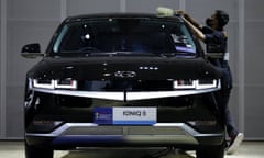 A man cleans a black Ioniq 5 at a motor show