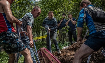 War crimes prosecutors at work during an exhumation in Mala Rohan, Kharkiv