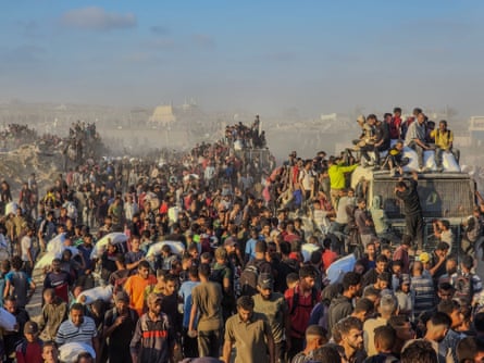 Crowd of people gather to get aid packages outside