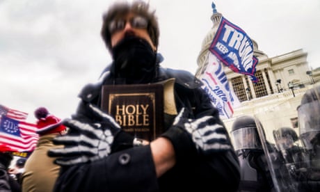 A man holds a Bible as Trump supporters gather outside the Capitol in Washington on 6 January 2021.