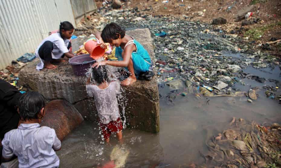 children at a water pipeline surrounded by sewage in Mumbai