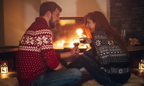 A couple drinking wine by a fireplace