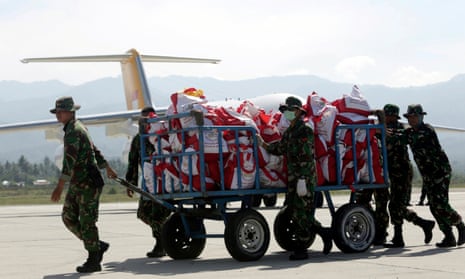 Troops unload aid supplies at Palu airport as international help began to arrive in Sulawesi.