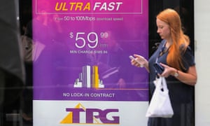 A woman walks past an ad for TPG