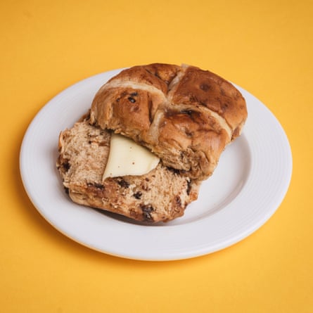 A Tesco Finest salted caramel & Belgian chocolate hot cross bun, sliced, toasted and buttered, on a white plate