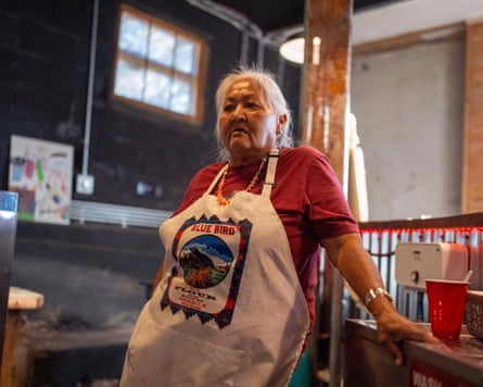 Virginia, wearing an apron, leaning on a kitchen counter