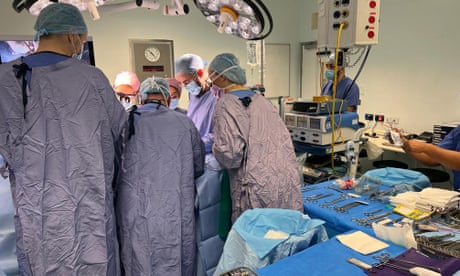 Surgeons seen gathered around the operating table during the the UK's first womb transplant