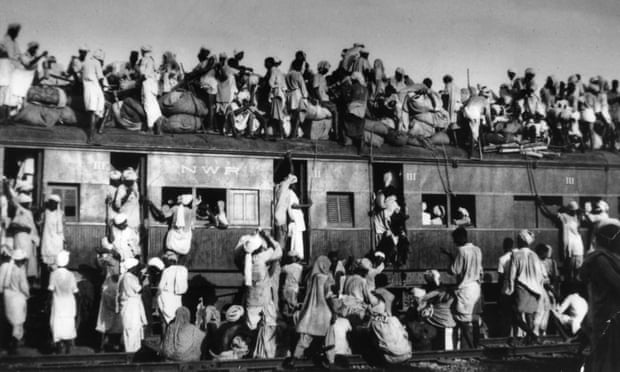 Muslim refugees attempting to flee India sit on the roof of an overcrowded train near Delhi in September 1947