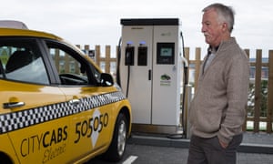 James Leaburn admires his electric taxi during a charging stop at the Princes Street charging station.