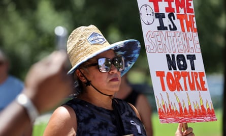 A woman holds up a sign during a demonstration against poor conditions caused by extreme heat in Texas jail cells
