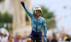 Mark Cavendish salutes the crowd as he crosses the finish line.