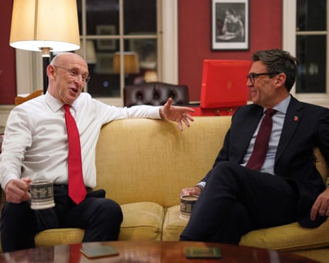 John Healey and Andy Burnham chatting on a sofa with cups of tea