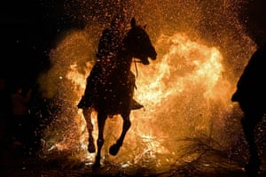 A horseman rides through a bonfire