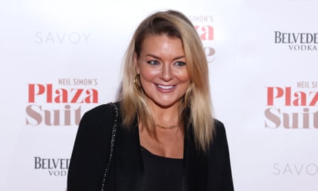 Sheridan Smith arrives at the Savoy Theatre, London, 28 Jan 2024; she has long, straight blonde hair and is wearing a black jacket with low-cut black top; she has gold earrings, a gold chain around her neck and a chain-detail strap to her handbag