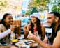 Young adults enjoying food and conversation outside.