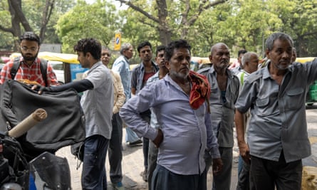 Men stand in the streets watching election results on a TV screen (not shown in the picture)