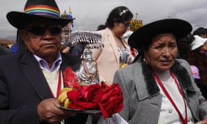 An elderly-looking couple march in the Corpus Christi procession during Inti Raymi. The man carries offerings of bread and fruit on a platter. The celebration includes 15 saints and holy virgins, each one representing a parish in Cusco. All are carried into the main cathedral at the end of the day.