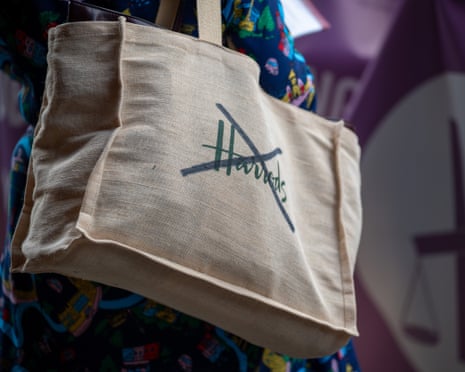 Shopping bag bearing Harrods logo crossed out with black marker