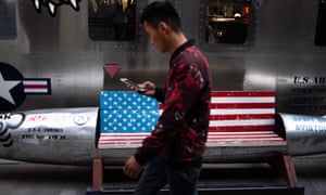 A man walks by a bench featuring a US flag outside a store in Beijing, China.