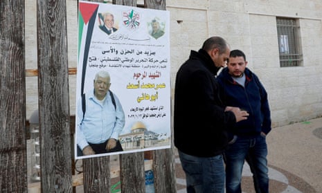 Men stand next to a poster of Palestinian Omar Abdalmajeed As'ad, in Jiljilya village in the Israeli-occupied West Bank