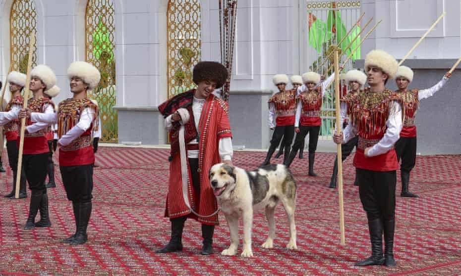 A man dressed in a national costume pets his border guard shepherd dog Alabai during the Dog Day celebration in Ashgabat