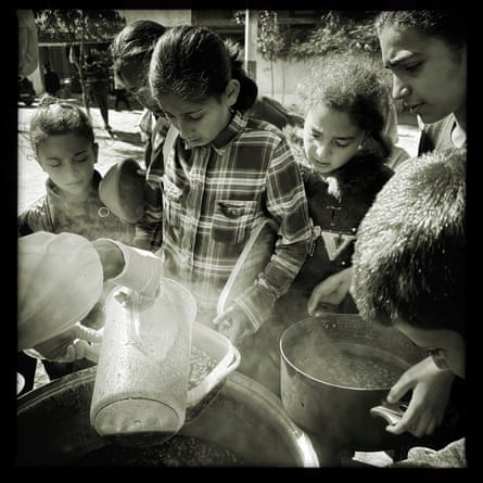 Children holding containers receive food handouts