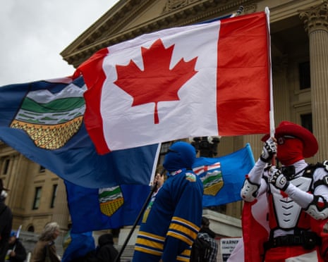 "Canada Guy" holds a Canadian flag amid Alberta flags outside the Alberta legislature