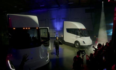 Elon Musk waves near Tesla Semi electric trucks during a live-streamed event in 2022