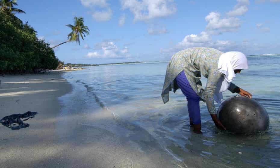 A villager washes a cooking pot in the sea around Huraa island, Maldives. The Green Climate Fund is allocating $23.6m to fight water shortages in the low lying atolls.