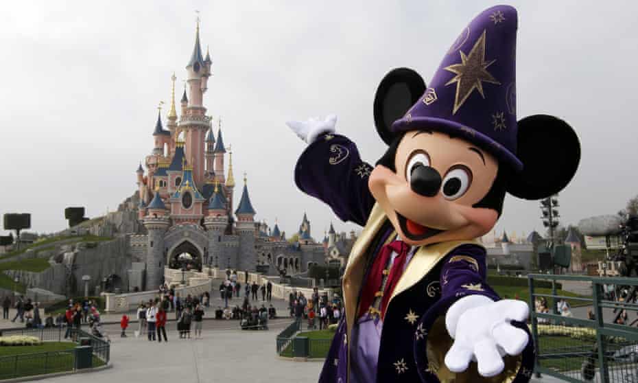 Mickey Mouse in front of the Sleeping Beauty castle at Disneyland Paris.