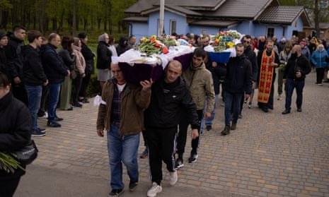 Local residents carry the caskets of two children who officials said were killed by a Russian missile strike in the town of Uman.