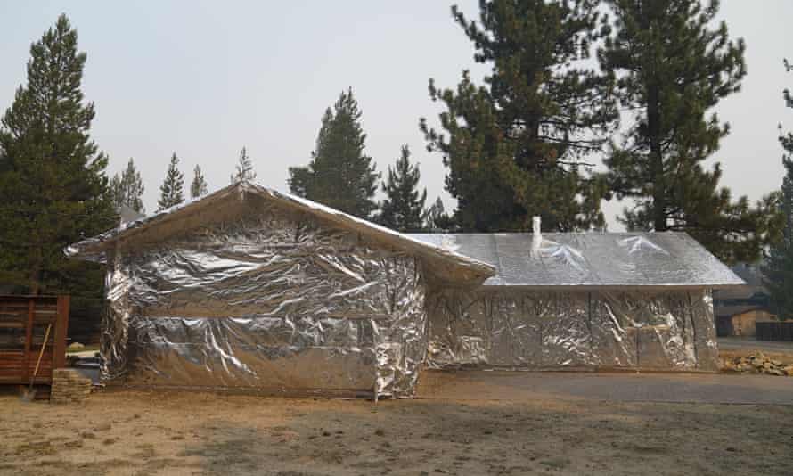 A home is completely wrapped in fire-resistant material in Meyers, California.