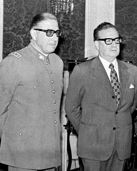Pinochet in military dress uniform stands next to Allende in a business suit