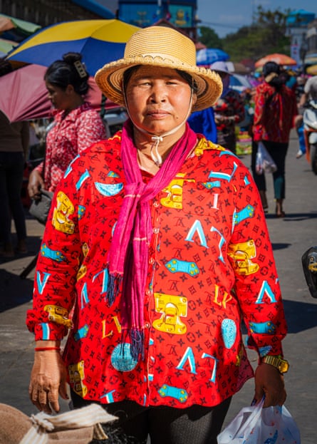 A woman in a bright blouse with LV on it