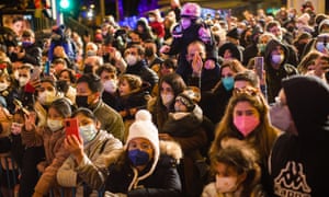 People under a bridge on La Castellana avenue in Madrid, Spain await the traditional Cavalcade of the Three Kings for Epiphany. People are all masked. Spain brought its outdoor mask mandate back in place last month.