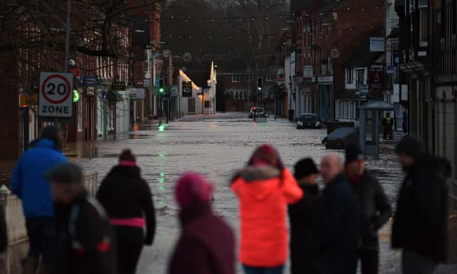People looking at flood water in Tenbury Wells after the River Teme burst its banks in western England.