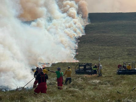 People trying to stop the fire spreading on moorland on 17 July
