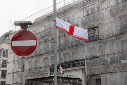 A St George flag in front of the scaffolded hotel