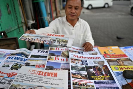A vendor arranges newspapers reporting on the general election in Yangon.