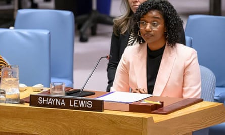 Shayna Lewis sitting at a desk in a conference hall