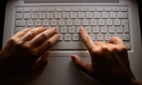 A woman types on a laptop