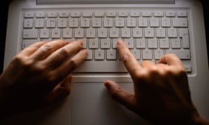 A woman types on a laptop