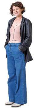 White woman with short curly hair, wearing v-neck crop top, leather coat, jeans and cowboy boots