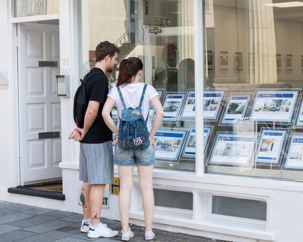 Young couple looking in estate agent’s window