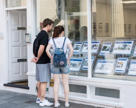Young couple looking in estate agent’s window
