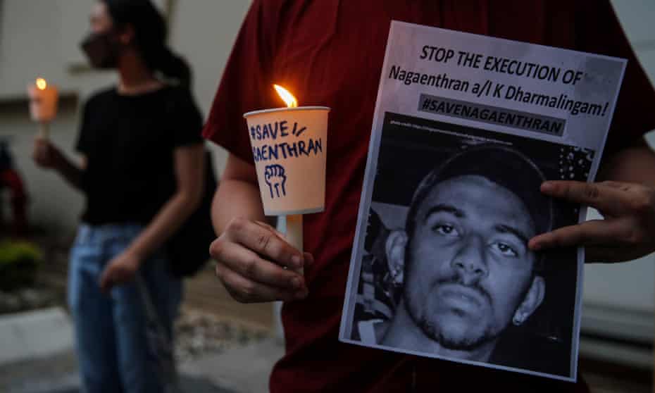 An activist holds a placard with candle during a vigil for Nagaenthran K Dharmalingam