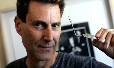 Uri Geller holds a spoon he claims to have bent using supernatural powers.