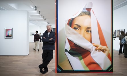 Marco Bischof poses next to a picture by his father at the Unseen Colour exhibition.