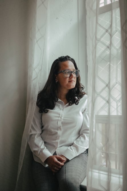 A younger woman sits near a window.