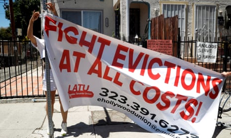Volunteers with the Los Angeles tenants union hang up a banner reading "Fight evictions at all costs!" outside the home of a person who has received an eviction notice in East Hollywood, California.